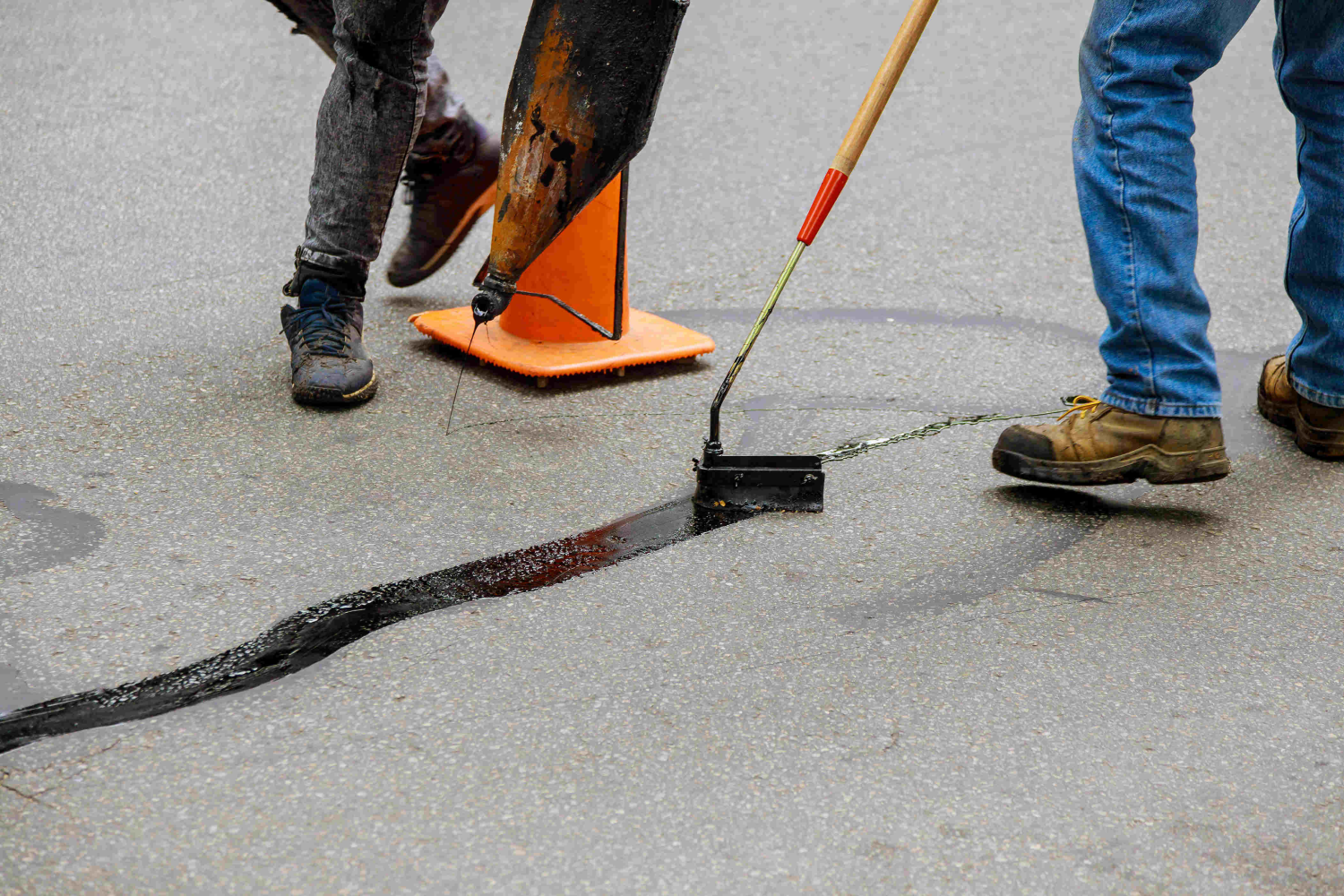 Professional crew performing crack sealing on asphalt pavement for long-term surface protection.