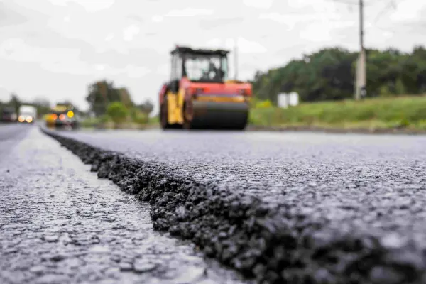 Heavy road roller compacting fresh asphalt during a professional asphalt paving project in North Georgia.